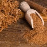 Sticks and ground ceylon cinnamon with wood spoon on wooden table